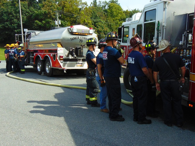 A tanker/tender using a nurse configuration supplies water to a fire engine.